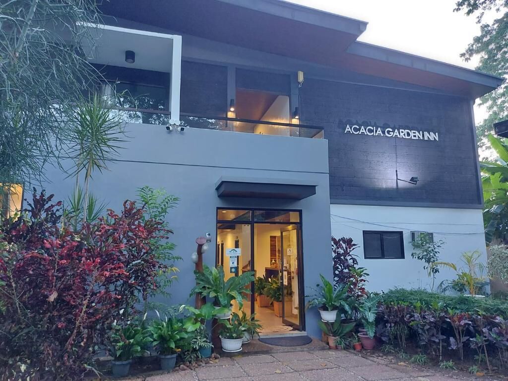 A modern building with a sign reading 'ACACIA GARDEN INN.'