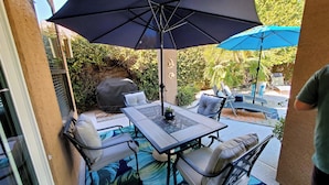 An outdoor patio with a table and chairs, a large umbrella, and a grill. - Resort Style 3 Bed, 3 Baths, Private Pool - Family Friendly -  Special CAD rate (Glendale)