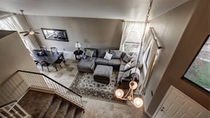 A spacious living room with a large gray sectional sofa, a dining area with a table and chairs, and a staircase leading to an upper floor. - Resort Style 3 Bed, 3 Baths, Private Pool - Family Friendly -  Special CAD rate (Glendale)