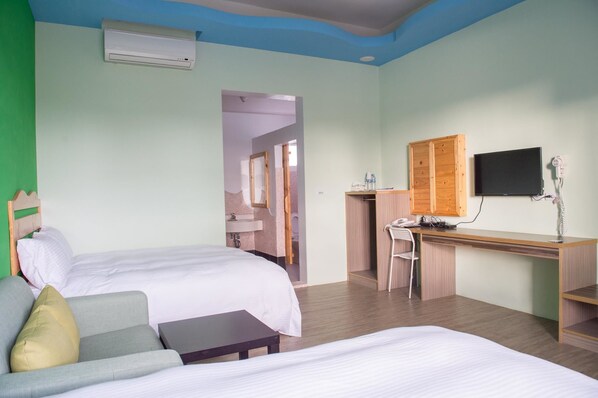 A hotel room with two beds, a desk, a chair, a TV, and an air conditioning unit. - Country Lane Hostel (Checheng)