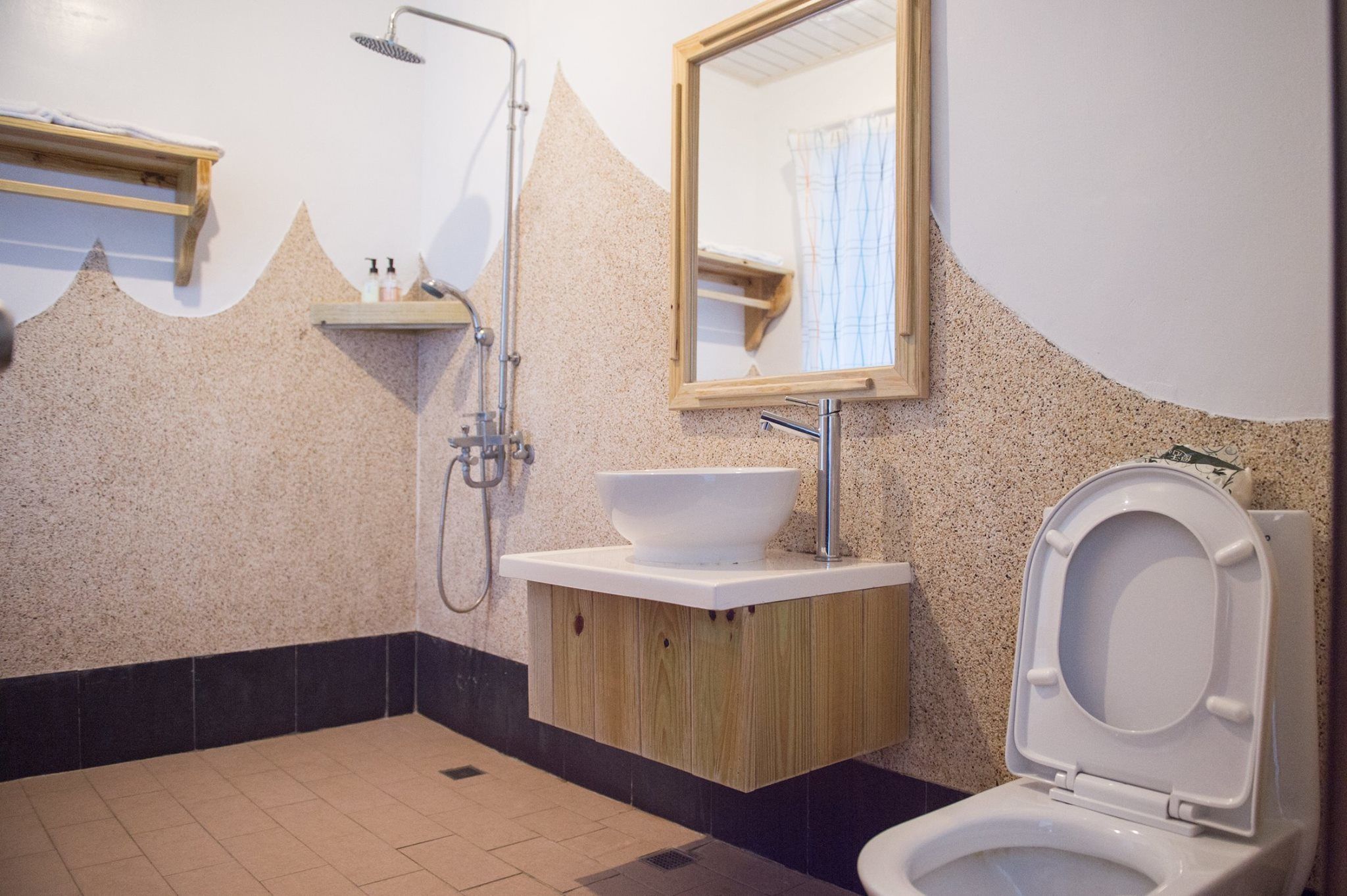 A bathroom with a sink, mirror, shower, and toilet.