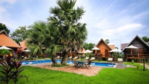 A resort with a swimming pool, outdoor seating, and wooden cabins. - Angkor Heart Village (Siem Reap)