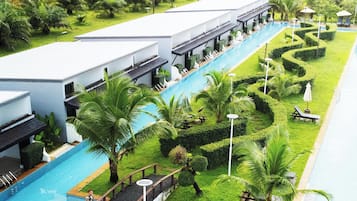 Un resort con piscina, sillas de descanso y palmeras.