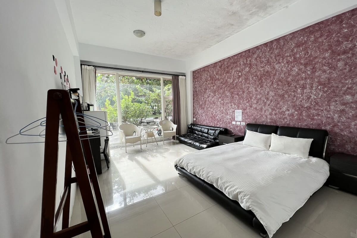 Una habitación de hotel moderna con una cama grande, un escritorio y una zona de estar con sillas.