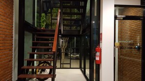 A modern staircase with a wooden handrail leading to a glass door. - The Connect Chiang Mai (Chiang Mai)