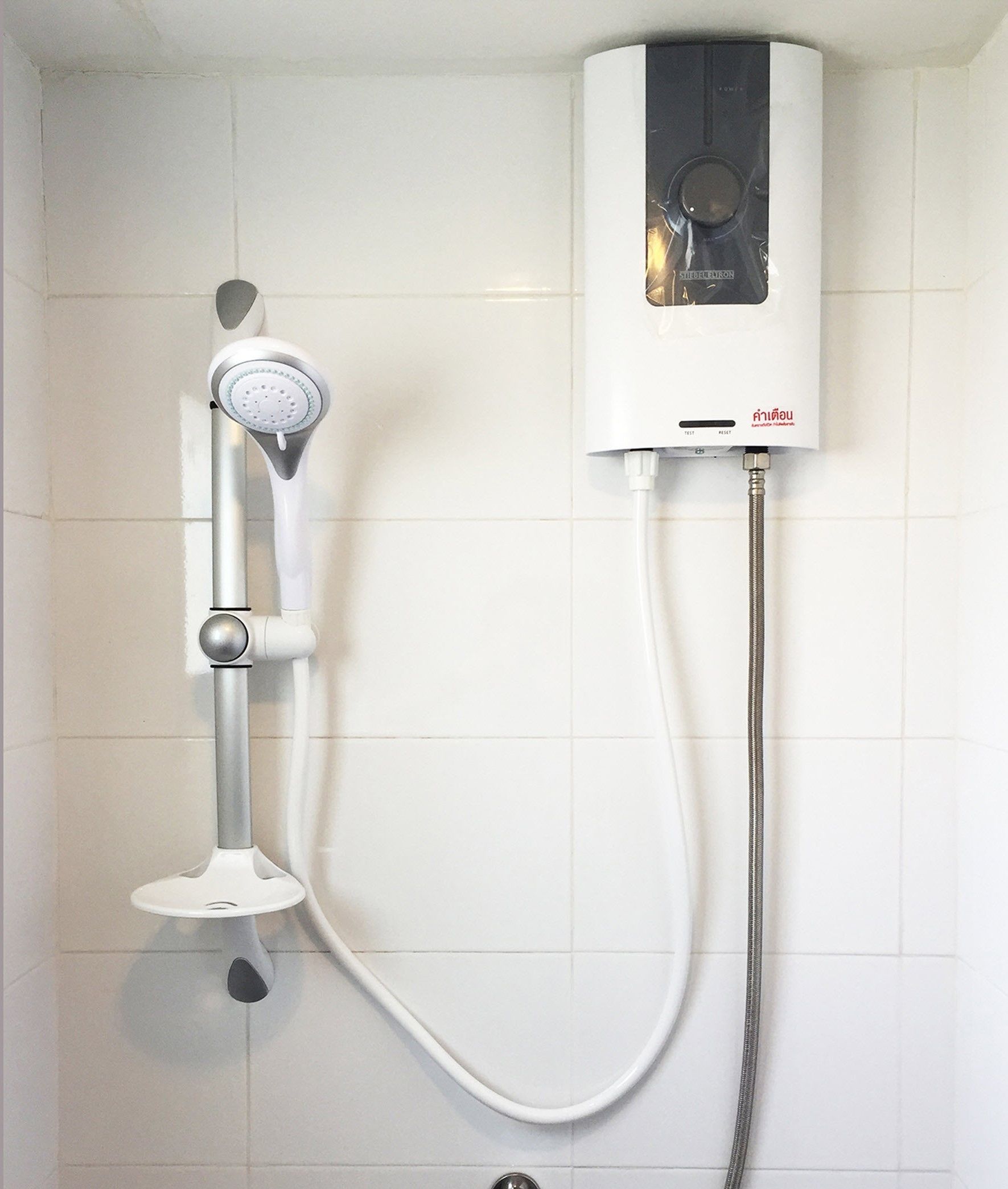 Ducha con cabezal de ducha de mano y panel de control empotrado.