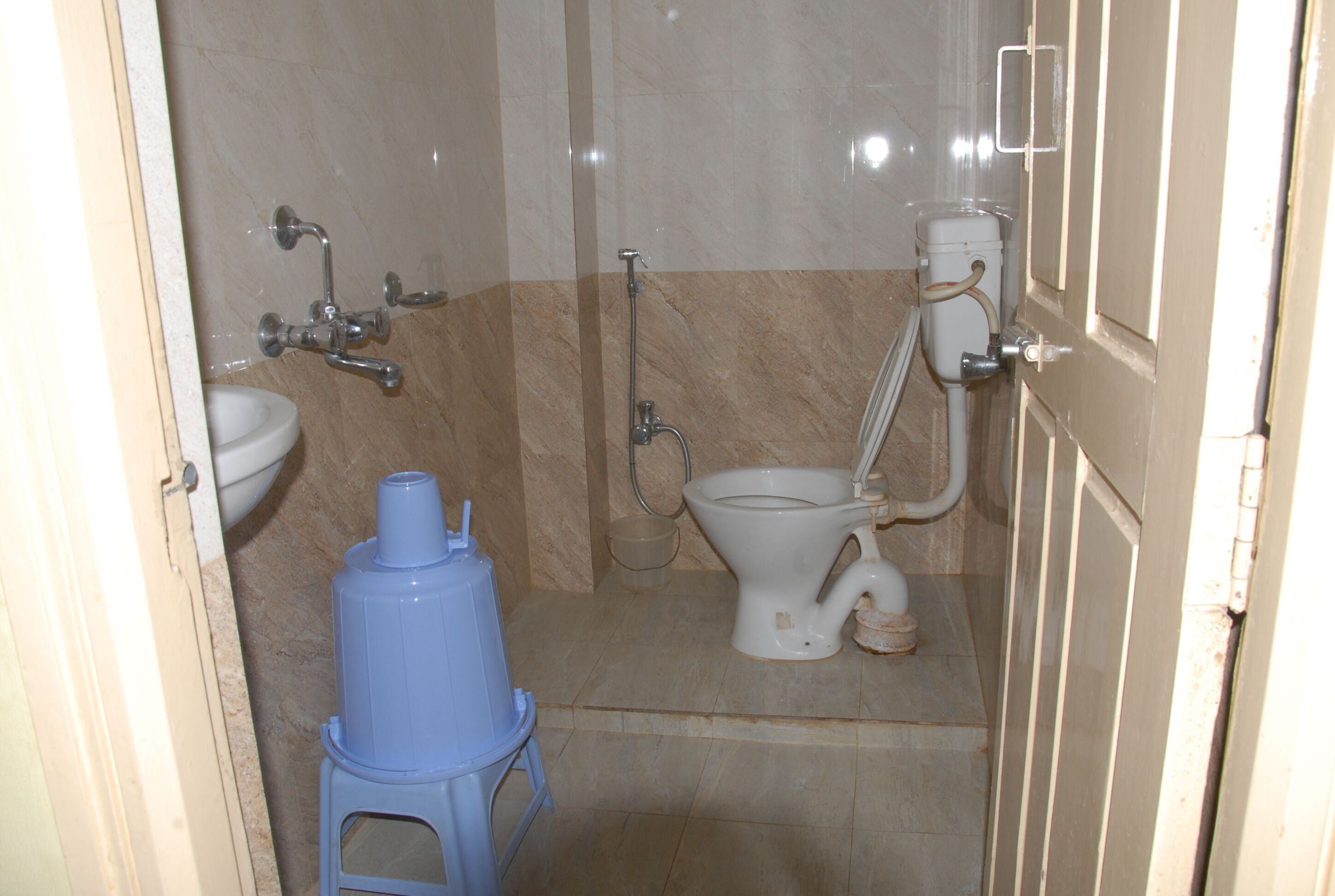 A small bathroom with a toilet, sink, and shower.