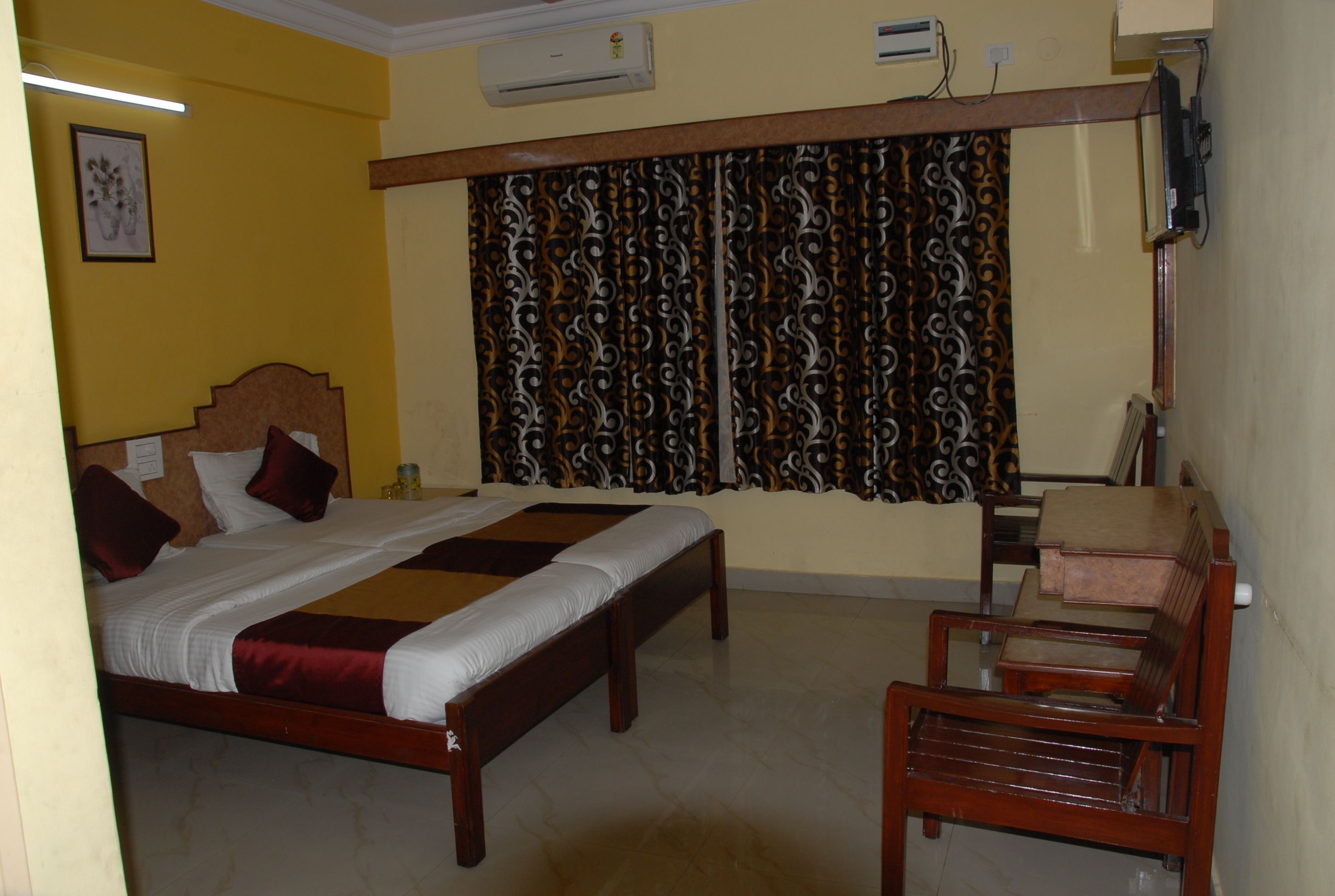 A bedroom with a bed, a desk, and a chair.