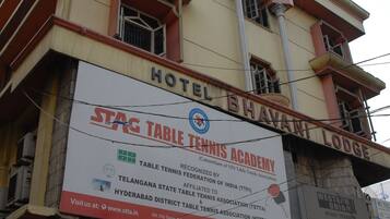 A building with a sign for Hotel Bhavani Lodge and STAG Table Tennis Academy.