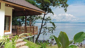 Una casa con terraza de madera que da a un lago.
