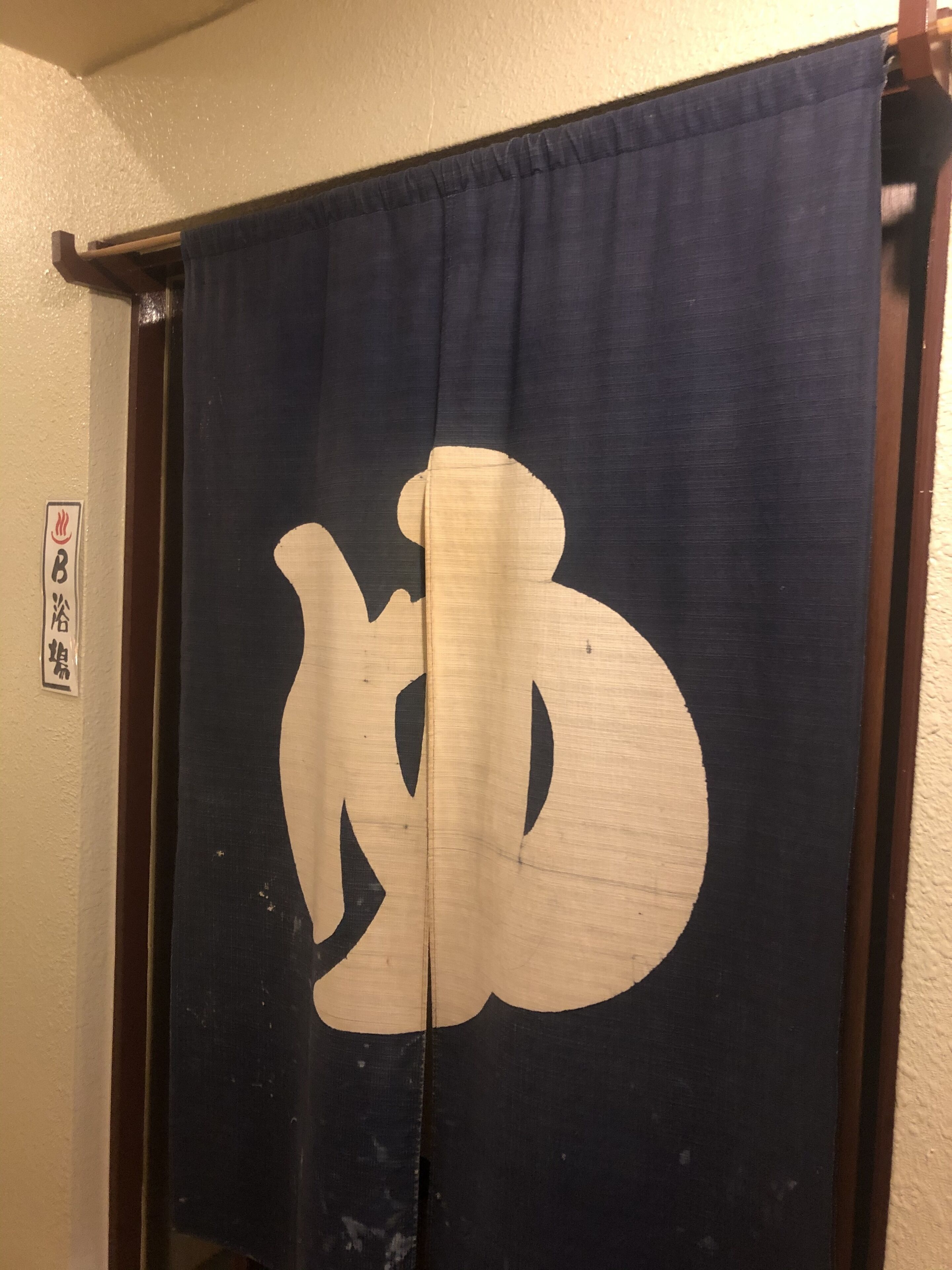A room with a dark blue curtain featuring a large white symbol.