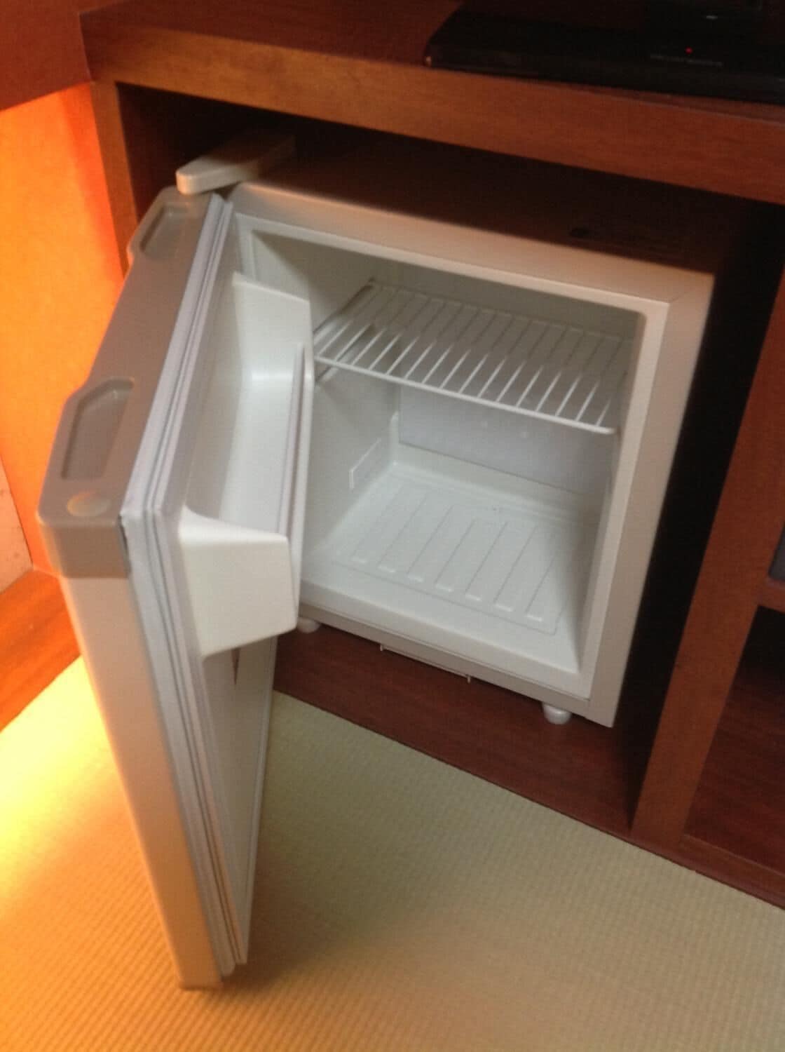 A compact refrigerator with a freezer compartment, built-in ice maker, and a water dispenser.