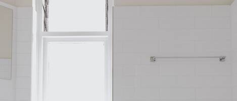 A bathroom with a white sink, a window, and a towel rack.
