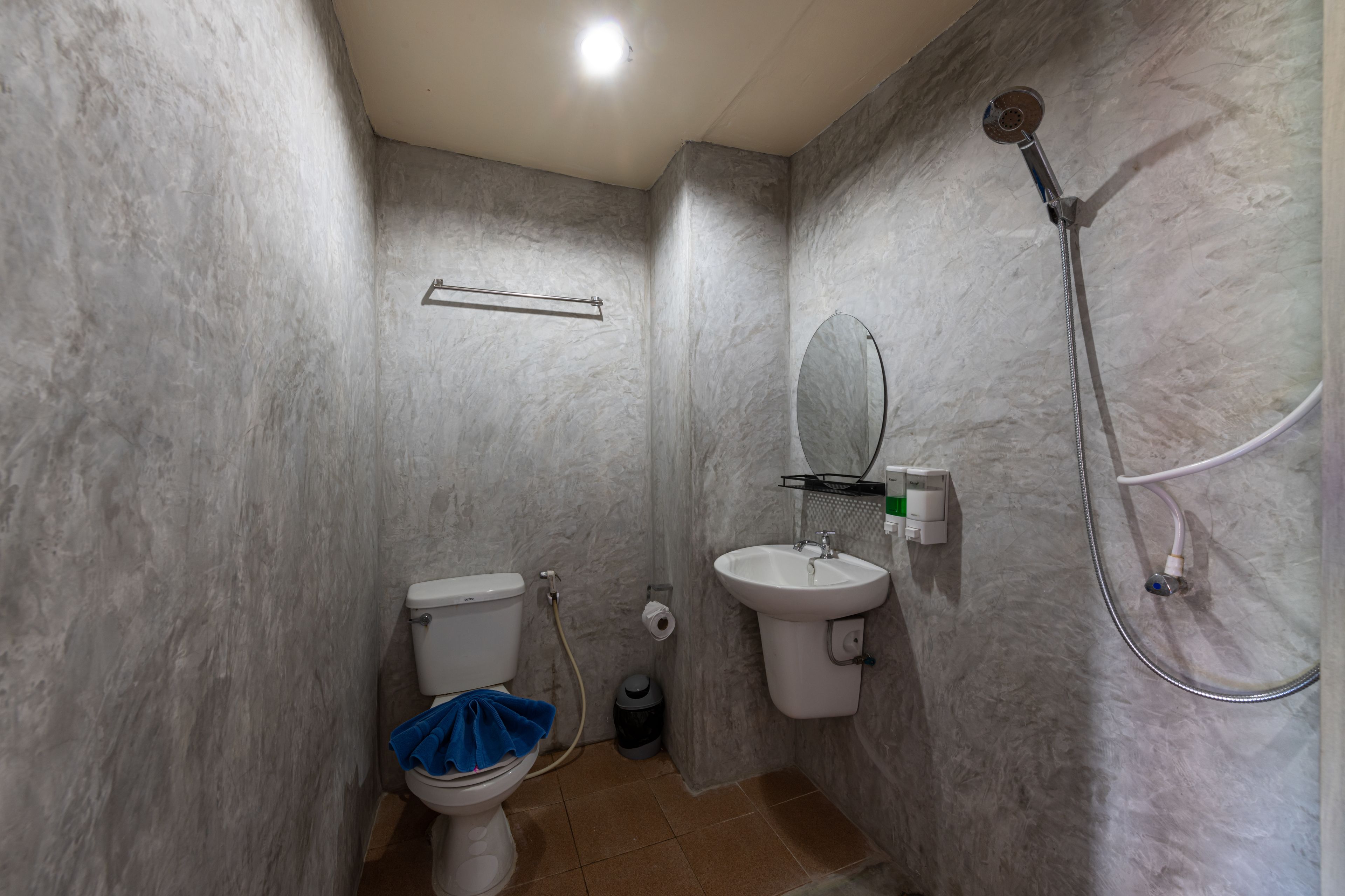 Un baño con inodoro, lavamanos y ducha.