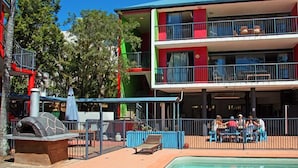 A two-story building with a pool, outdoor seating, and a barbecue area. - Mooloolaba Backpackers (Mooloolaba)