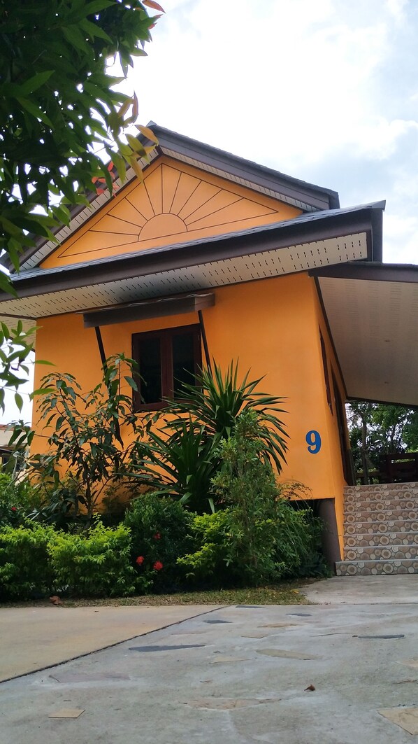 A house with a yellow exterior, a window, and a number '9' on the side.