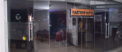 A glass-fronted entrance to a restaurant with a sign reading "Earth Oven."