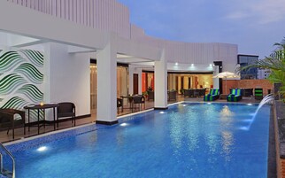 A swimming pool area with lounge chairs and a bar.
