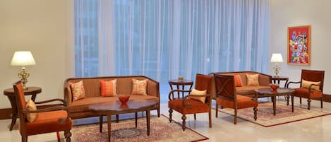 A modern living room with a sofa, chairs, a coffee table, and a rug.
