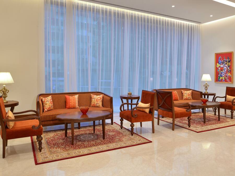 A modern living room with a sofa, chairs, a coffee table, and a rug.