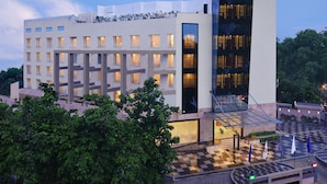 A modern hotel with a prominent 'FORTUNE' sign, multiple floors, and a checkered outdoor area.