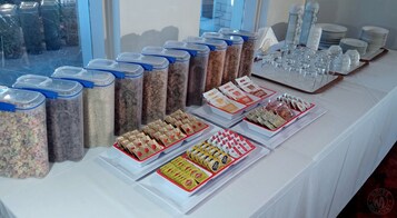 Una mesa de buffet con diversos alimentos y recipientes.