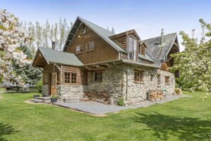 A log cabin with a stone foundation, a sloped roof, and a wooden exterior. - Galaxy Lounge (Burkes Pass)