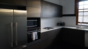 A modern kitchen with stainless steel appliances, a microwave, and a gas stove. - Guildford Hotel (Guildford)