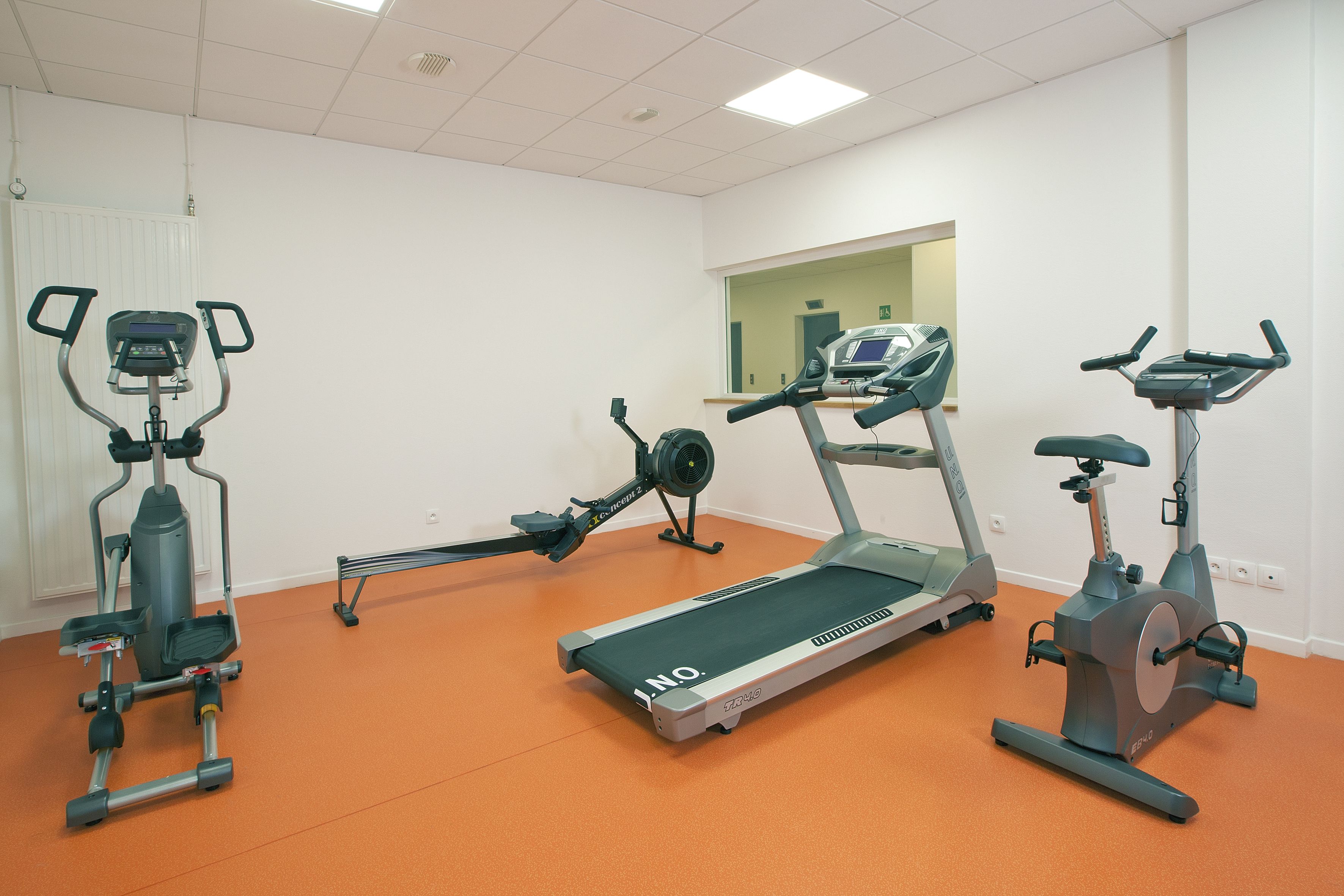 A gym with treadmills, elliptical machines, and a stationary bike.