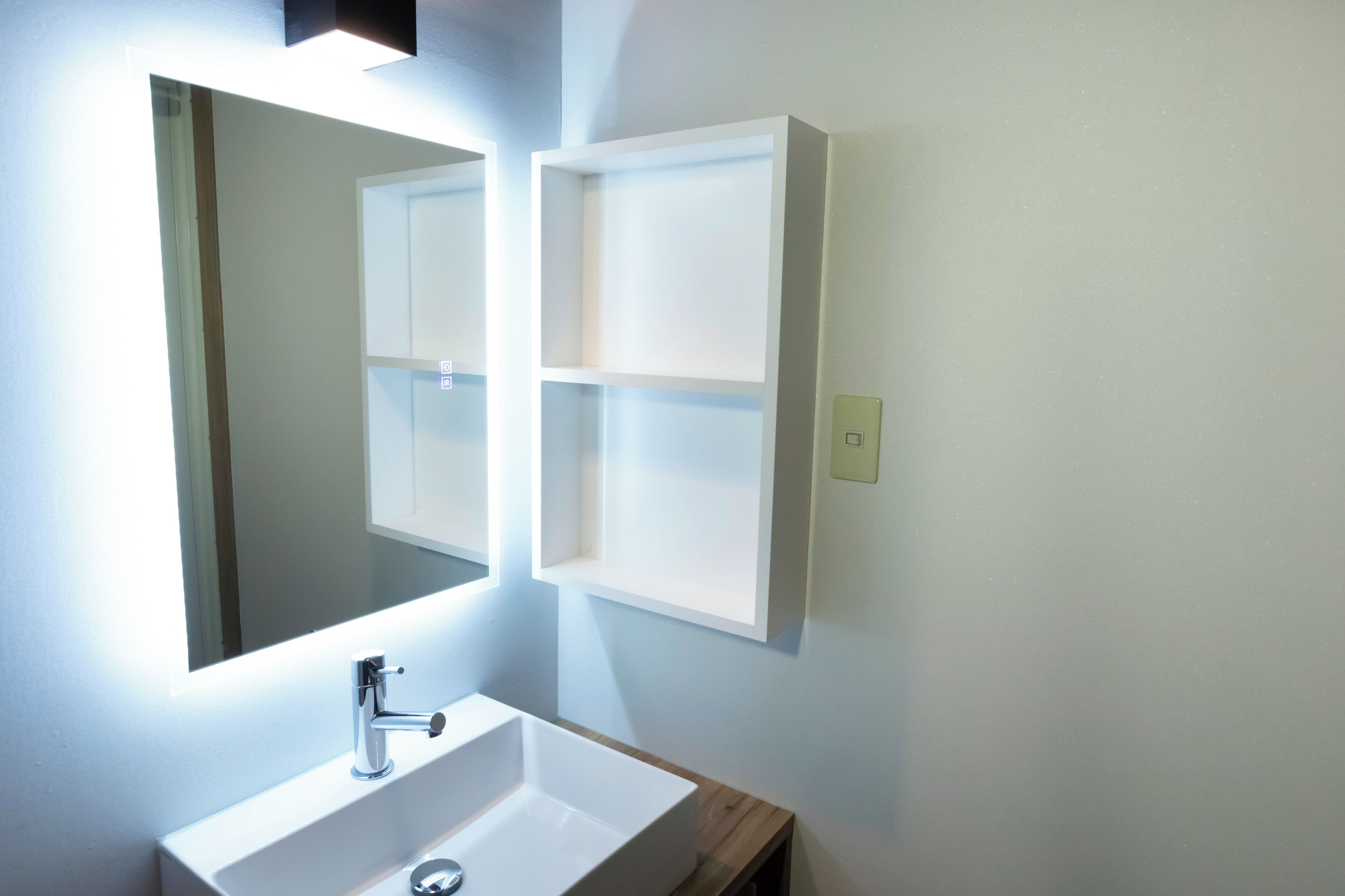 A bathroom with a white sink, a mirror, and a medicine cabinet.