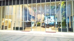 A modern building with large glass windows, a central staircase, and indoor seating areas. - UCSI Hotel Kuching (Kuching)