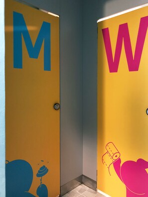 Two doors with large letters 'M' and 'W' on a yellow background, each door has a small circular handle. - Sohostel Korea (Busan)
