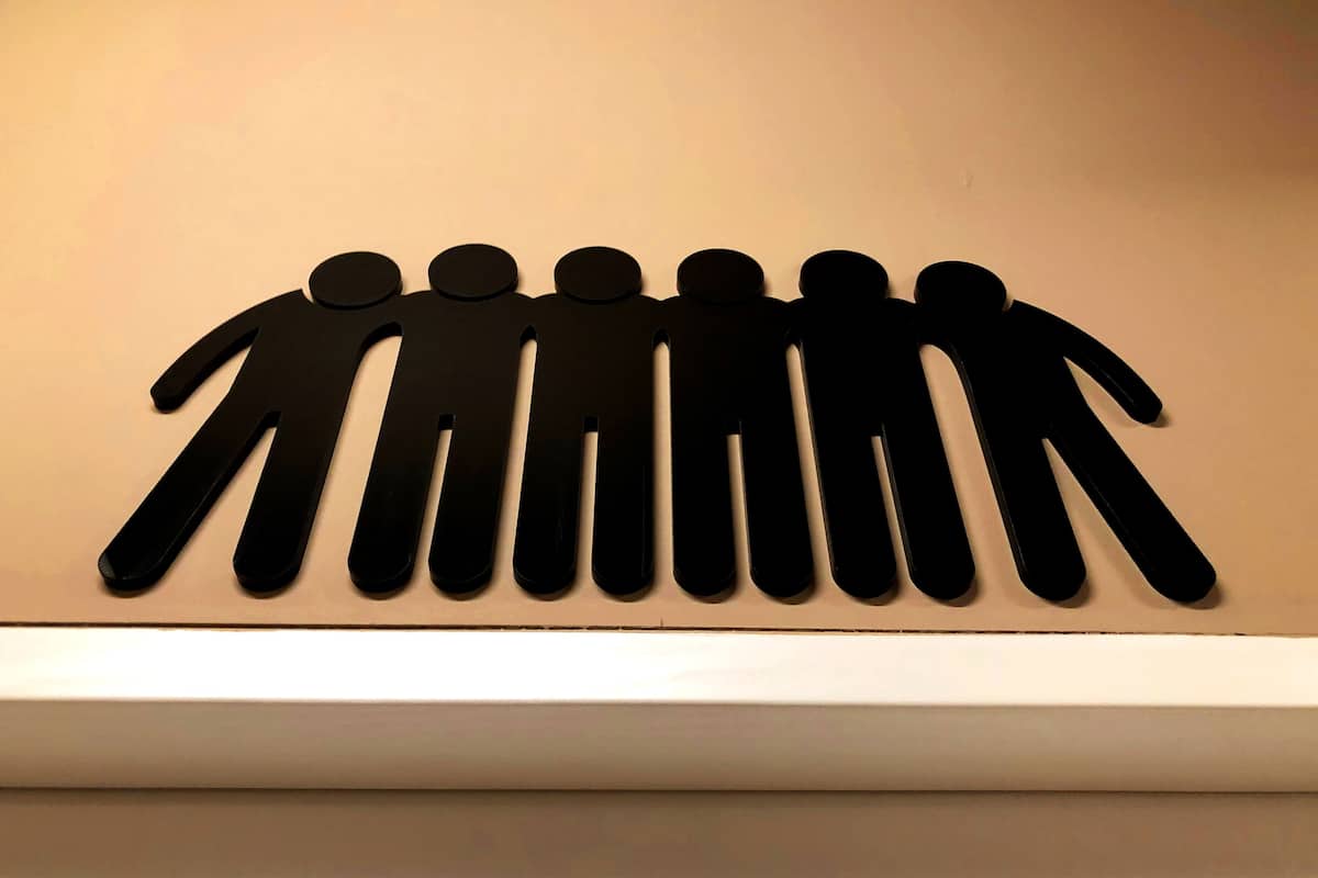 A wall-mounted cutout of seven figures in a row.