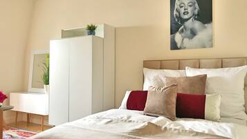 Un dormitorio con cama, cómoda, espejo y un cuadro en la pared.