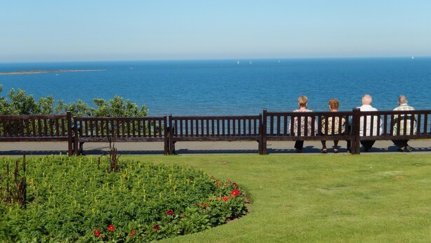 A bench overlooking a coastal view with a clear sky. - Athol Guest House (Filey)