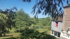 Une vue d’une zone riveraine avec un petit bâtiment en bois et une végétation luxuriante.