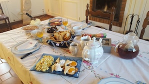 Une table de petit-déjeuner dressée avec différents plats, notamment des œufs, des toasts et des boissons.