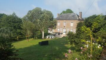 A large brick house with a well-maintained lawn and a patio area.