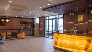 A modern hotel lobby with a reception desk, seating area, and a bar. - Paradiso Apartcomplex (Nessebar)