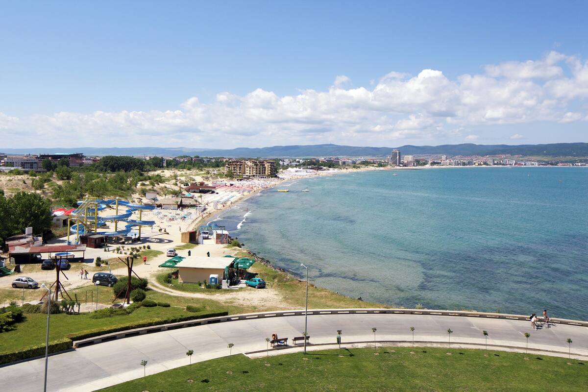 Eine Küstenlandschaft mit Strand, Wasser und einer Straße.