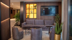 A modern living room with a grey sofa, two round coffee tables, and potted plants. - Paradiso Apartcomplex (Nessebar)