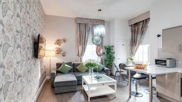 Apartamento luxo, 2 quartos | Área de estar | TV de tela plana