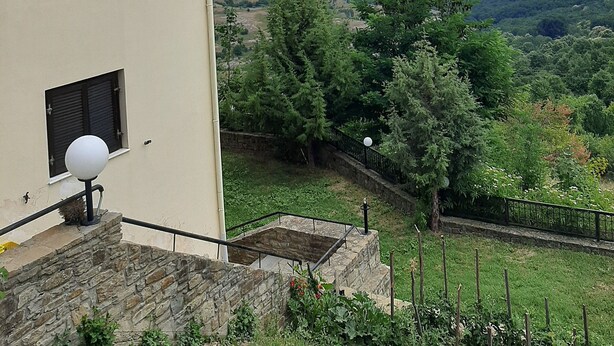 A building with a stone staircase and a view of a green landscape. - Guest House Ilektra (Voio)
