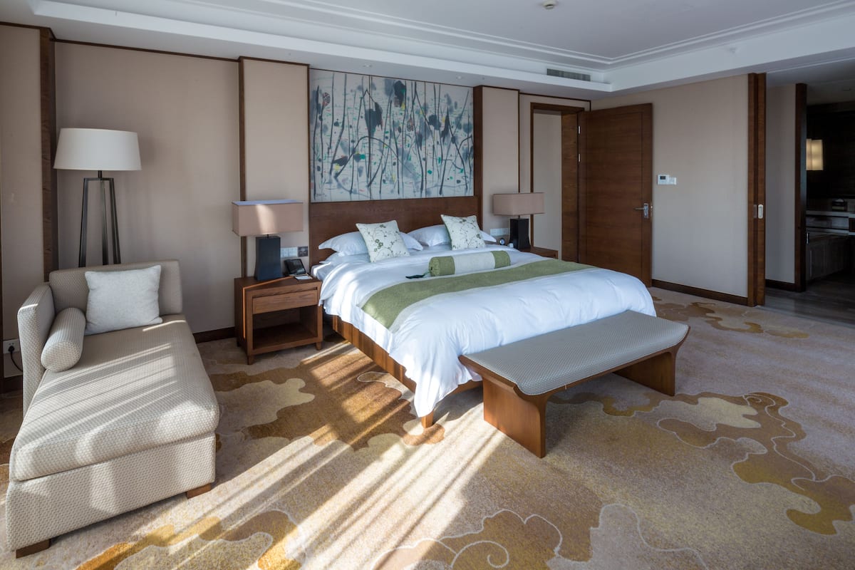 Ein Hotelzimmer mit einem großen Bett, einer Couch, einem Schreibtisch und einem Bild an der Wand.