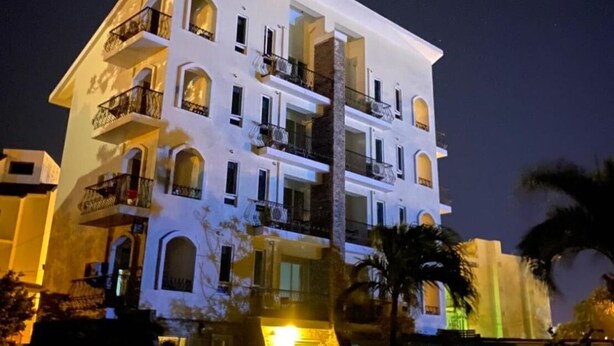 A multi-story hotel with balconies and a central column. - MaMaLuLu Hostel (Hengchun)
