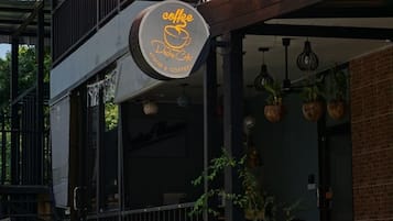 Une enseigne indiquant l’emplacement de l’auberge de jeunesse Decho et une enseigne d’un café.