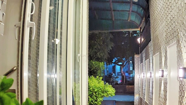 Un pasillo con suelo a cuadros, puertas de vidrio y plantas en macetas.