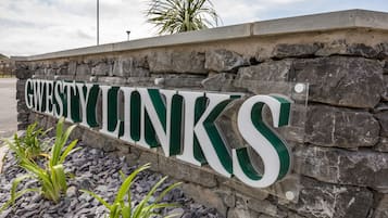 A sign with the name "GUESTWINKS" on a stone wall.