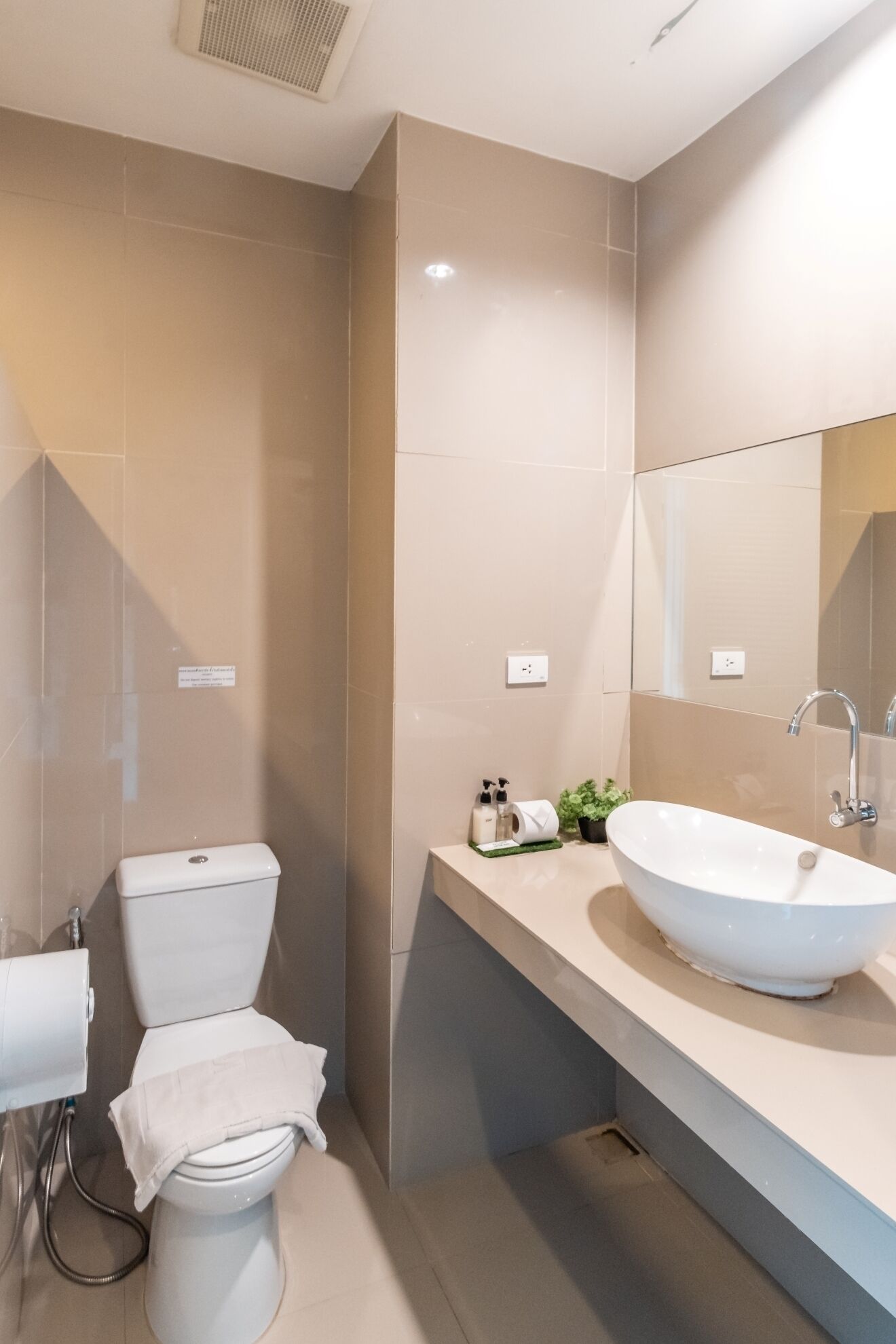 Un baño moderno con inodoro, lavabo y espejo.