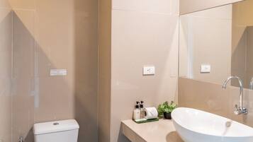 Un baño moderno con inodoro, lavabo y espejo.